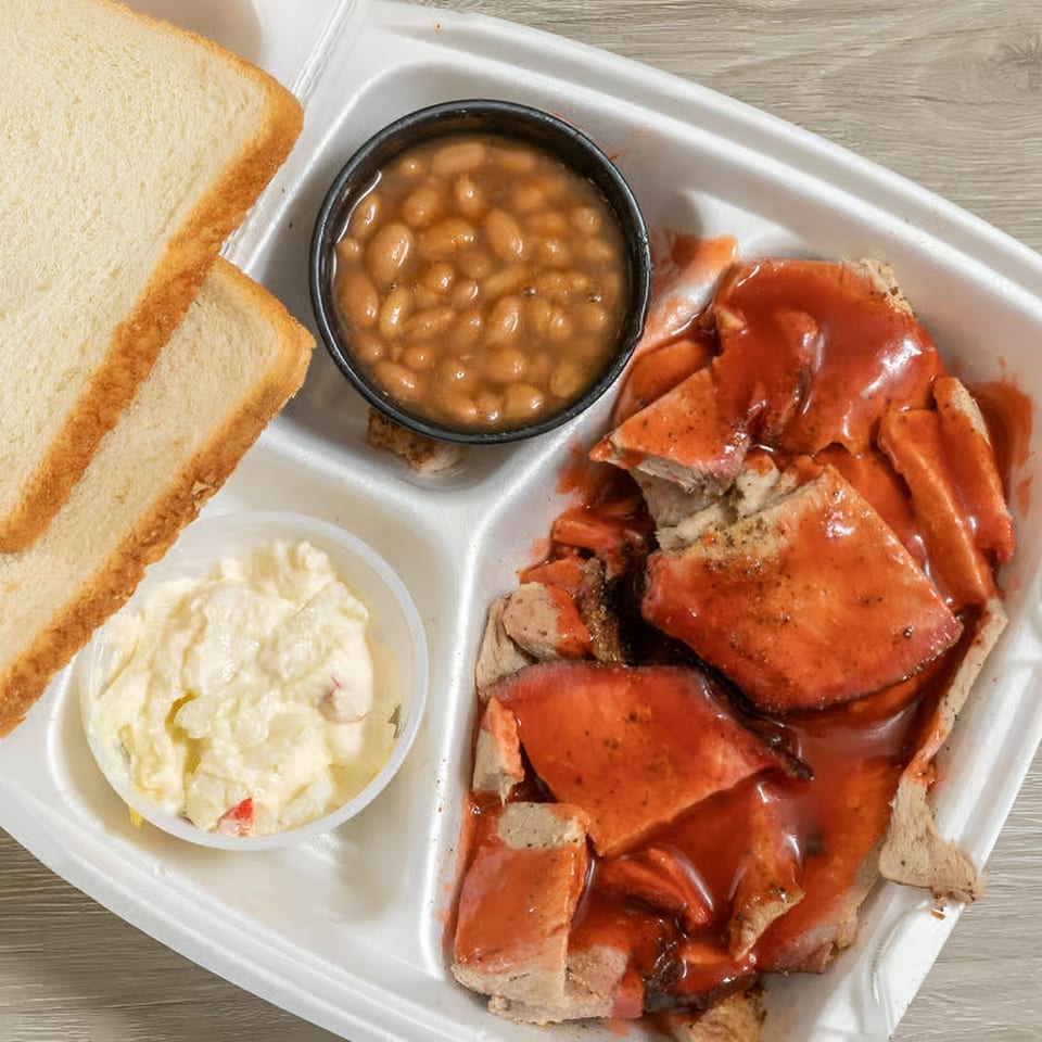 Ashley's Bar-B-Que sliced pork with red sauce, baked beans, potato salad, and white bread.
