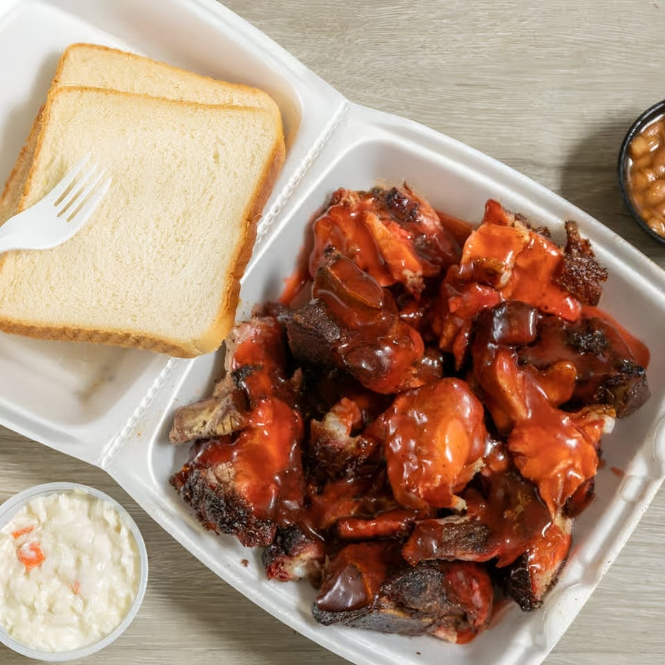 Ashley's Bar-B-Que chopped pork with red sauce, white bread, coleslaw, and baked beans.